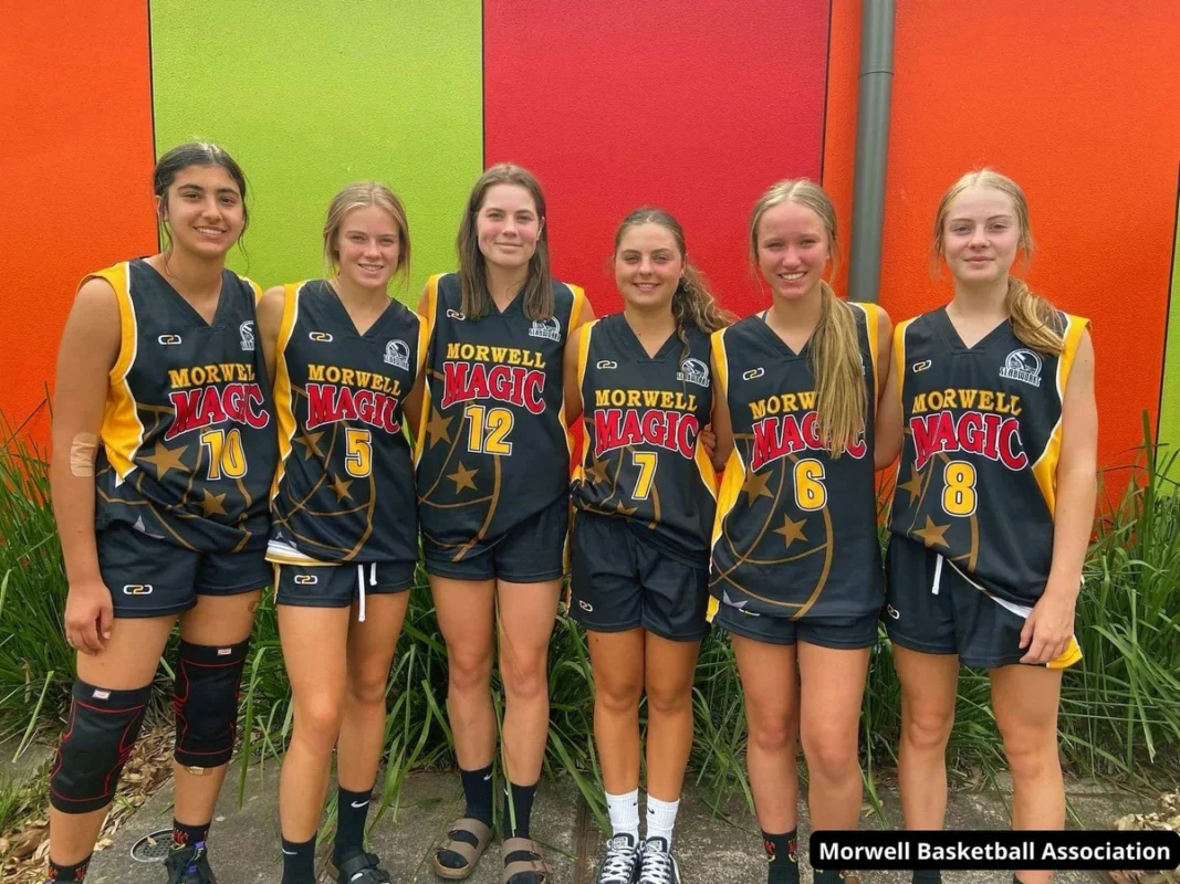 Players demonstrating custom netball uniforms provided by direct manufacturer